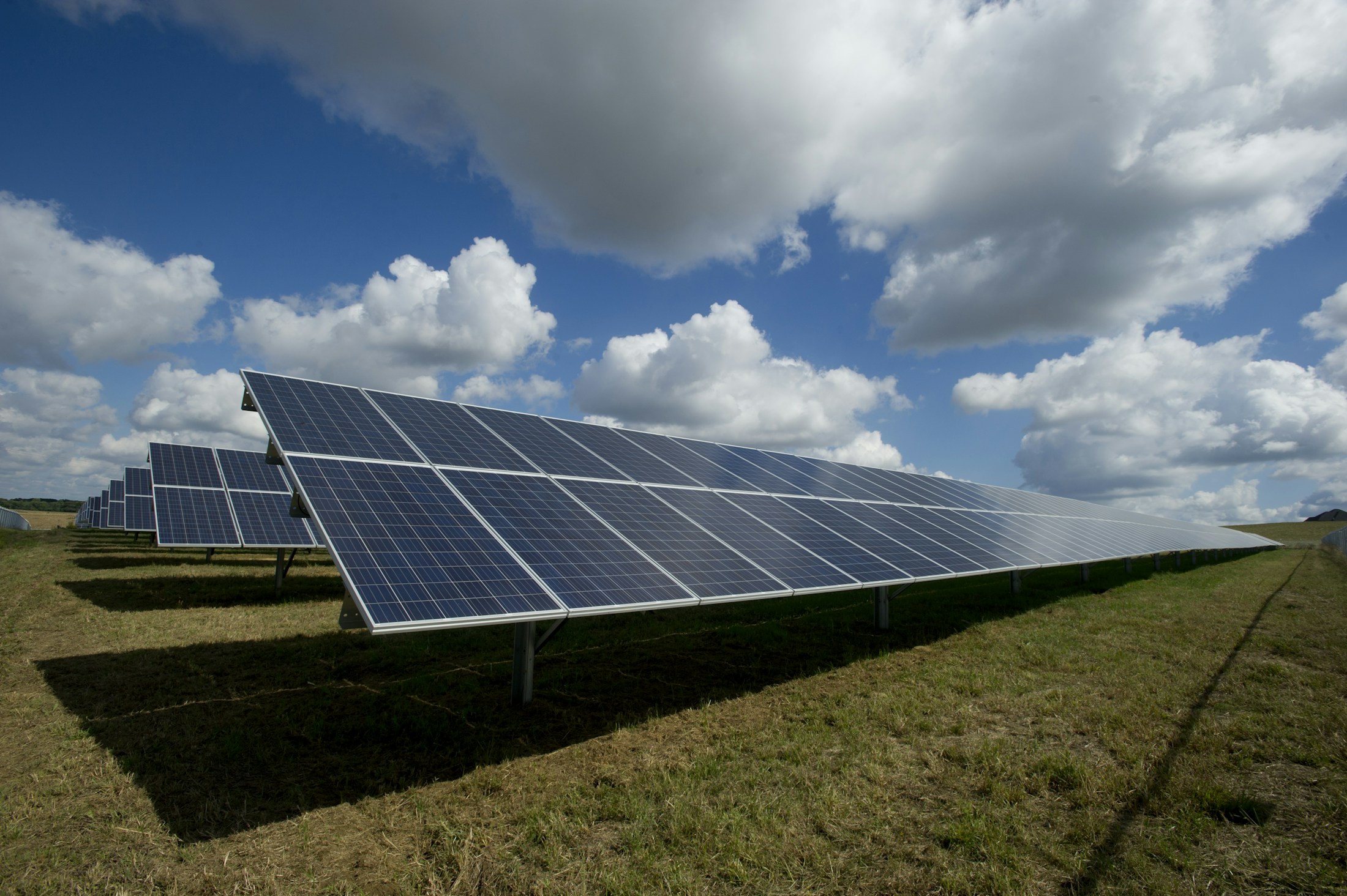 Rows of solar panels collecting sunlight across an open landscape